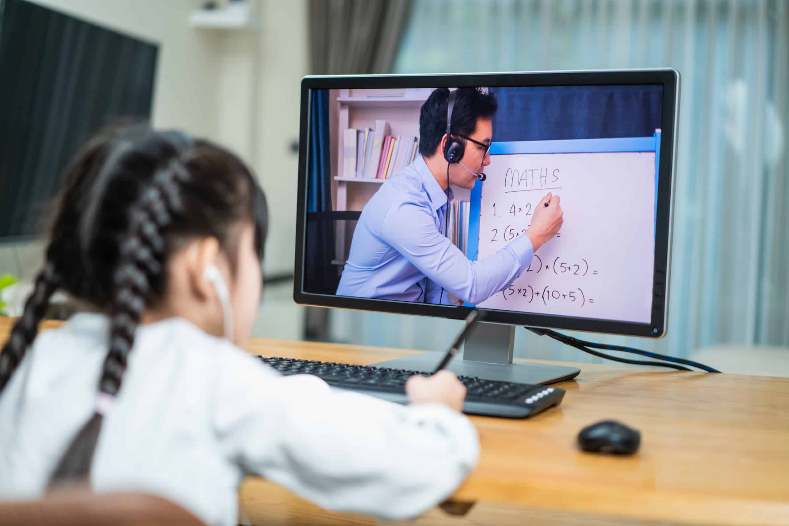 Asian homeschool girl learning online with mathematic teacher at home.
