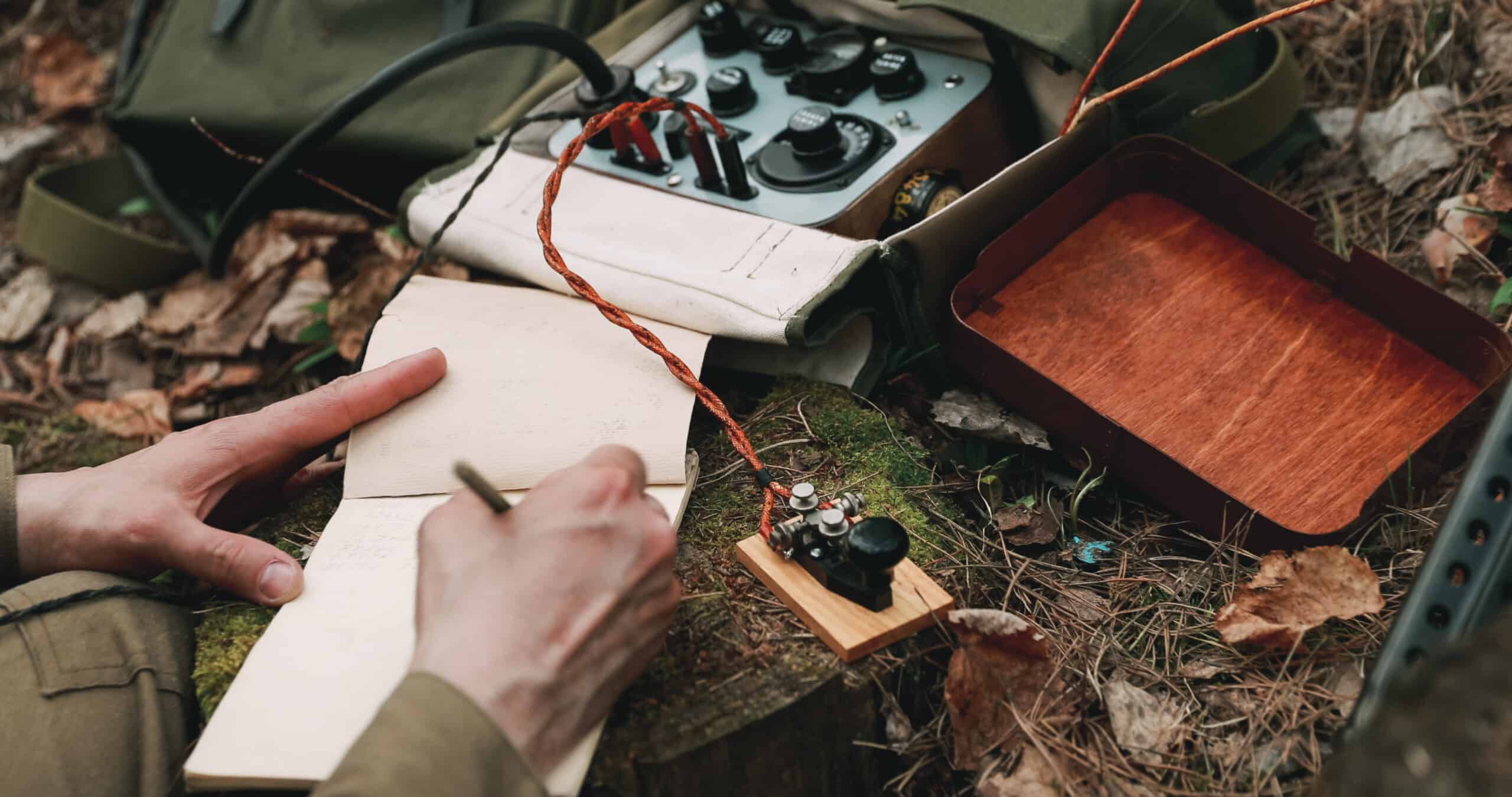 Russian Soviet Infantry Red Army Soldier In World War II using Russian Soviet Portable Radio Transceiver In Trench Entrenchment In Spring Autumn Forest. . Headphones And Telegraph Key. Close Up Hands
